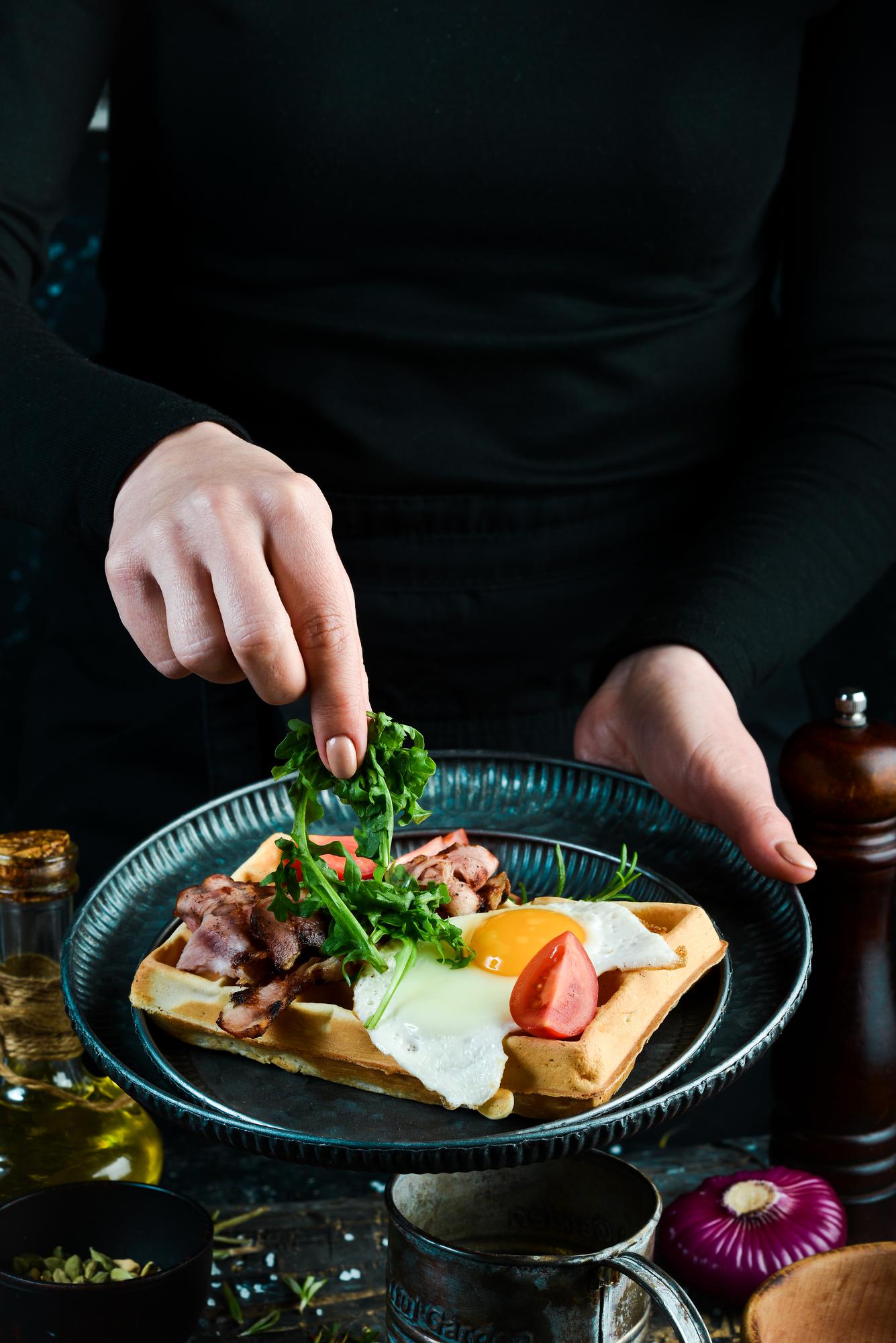 Chef arranging plated dish on wooden table